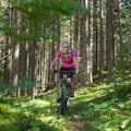 Active sporty woman riding mountain bike on forest trail . Royalty Free Stock Photo