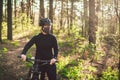 Active sporty woman riding mountain bike on forest trail, wearing a face mask against air pollution and covid19 coronavirus. Royalty Free Stock Photo