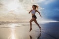 Active sporty woman run along sunset ocean beach. Sports background. Royalty Free Stock Photo