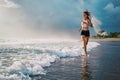 Active sporty woman run along sunset ocean beach. Sports background. Royalty Free Stock Photo