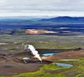 Active steam stack and parts of Krafla geothermal power plant next by the volcano crater with Krafla Viti lake in Nordurland Royalty Free Stock Photo