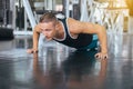 Active strong man doing push up and exercises on floor at gym