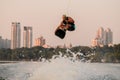 active strong man making trick in jump time with wakeboard on city background. Royalty Free Stock Photo