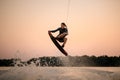 active strong man making trick in jump time with wakeboard on sky background. Royalty Free Stock Photo