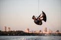 active strong man rider holds rope and skilfully making extreme jump showing trick on wakeboard.