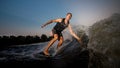 Active strong young man riding down the river waves in evening Royalty Free Stock Photo