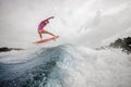 Active teenager girl jumping on the orange wakeboard on the rive Royalty Free Stock Photo