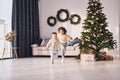 Active time spending. Little brother and sister is at christmas decorated room together Royalty Free Stock Photo