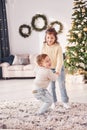 Active time spending. Little brother and sister is at christmas decorated room together Royalty Free Stock Photo