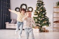 Active time spending. Little brother and sister is at christmas decorated room together Royalty Free Stock Photo