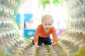 Active toddler boy having fun on inflatable attraction in entertaining center. Funny child is playing on indoor playground. Kids Royalty Free Stock Photo