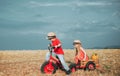 Active toddler kid playing and cycling outdoors. Two Kids having fun in field against blue sky background. Earth day Royalty Free Stock Photo