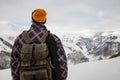 Active tourist with backpack enjoying the view on top of snowy mountain. Royalty Free Stock Photo