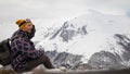 Active tourist with backpack enjoying the view on top of snowy mountain. Royalty Free Stock Photo