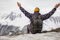 Active tourist with backpack enjoying the view on top of snowy mountain. Royalty Free Stock Photo