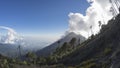 Active volcano Fuego surrounded by trees and clouds, Guatemala