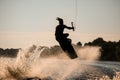 Active wakeboarder jumping with board over splashing river wave Royalty Free Stock Photo