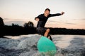 Active wakesurfer in black swimsuit jumping on a wake board Royalty Free Stock Photo