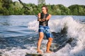 Active wakesurfer jumping on wake board down the river waves. Surfer on wave. Male athlete training on wakesurf training