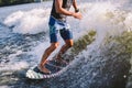 Active wakesurfer jumping on wake board down the river waves. Surfer on wave. Male athlete training on wakesurf training. Active