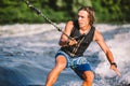 Active Wakesurfer Jumping On Wake Board Down The River Waves. Surfer On Wave. Male Athlete Training On Wakesurf Training