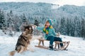 Active winter outdoors games for kids with dog. Happy Christmas vacation concept. Boy enjoying winter, playing with Royalty Free Stock Photo