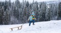 Active winter outdoors games for kids. Happy Christmas vacation concept. Boy enjoying winter, playing with sleigh ride Royalty Free Stock Photo