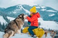 Active winter outdoors games for kids. Happy Christmas vacation concept. Boy enjoying winter with siberian husky dog Royalty Free Stock Photo