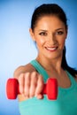 active woman with dumbbells workout in fitness gym over blue background