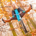 Active woman having fun riding bike in autumn park Royalty Free Stock Photo