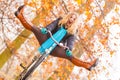 Active woman having fun riding bike in autumn park Royalty Free Stock Photo