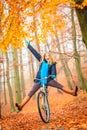 Active woman having fun riding bike in autumn park Royalty Free Stock Photo