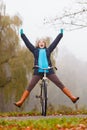 Active woman having fun riding bike in autumn park Royalty Free Stock Photo