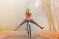 Active woman having fun riding bike in autumn park Royalty Free Stock Photo