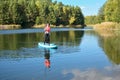 Active woman paddling SUP board on beautiful lake, autumn forest landscape and nature on background Royalty Free Stock Photo