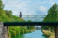 Active woman runner jogging across river bridge, outdoors running