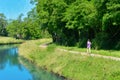 Active woman runner jogging near canal river, outdoors running