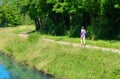 Active woman runner jogging near canal river, outdoors running