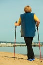 Active woman senior nordic walking on a beach. from behind Royalty Free Stock Photo