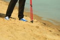 Active woman senior nordic walking on a beach. legs Royalty Free Stock Photo