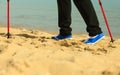 Active woman senior nordic walking on a beach. legs Royalty Free Stock Photo