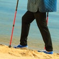 Active woman senior nordic walking on a beach. legs Royalty Free Stock Photo