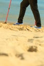 Active woman senior nordic walking on a beach. legs Royalty Free Stock Photo