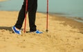 Active woman senior nordic walking on a beach. legs Royalty Free Stock Photo