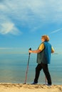 Active woman senior nordic walking on a beach