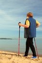 Active woman senior nordic walking on a beach Royalty Free Stock Photo