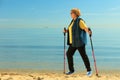 Active woman senior nordic walking on a beach Royalty Free Stock Photo