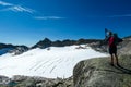 An active woman standing on a rock with view on the glacier of Hoher Sonnblick in Hohe Tauern in Carinthia, Salzburg, Austria