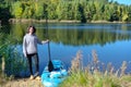 Active woman with SUP board near beautiful lake, nature on background, stand up paddling water adventure outdoors Royalty Free Stock Photo