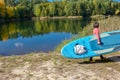 Active woman with SUP board near beautiful lake, nature on background, stand up paddling water adventure outdoors Royalty Free Stock Photo